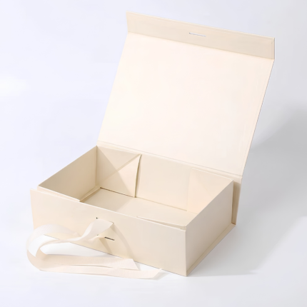 Open beige foldable gift box with magnetic closure and matching ribbon.