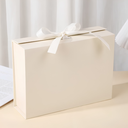 Open beige foldable gift box with magnetic closure and matching ribbon.