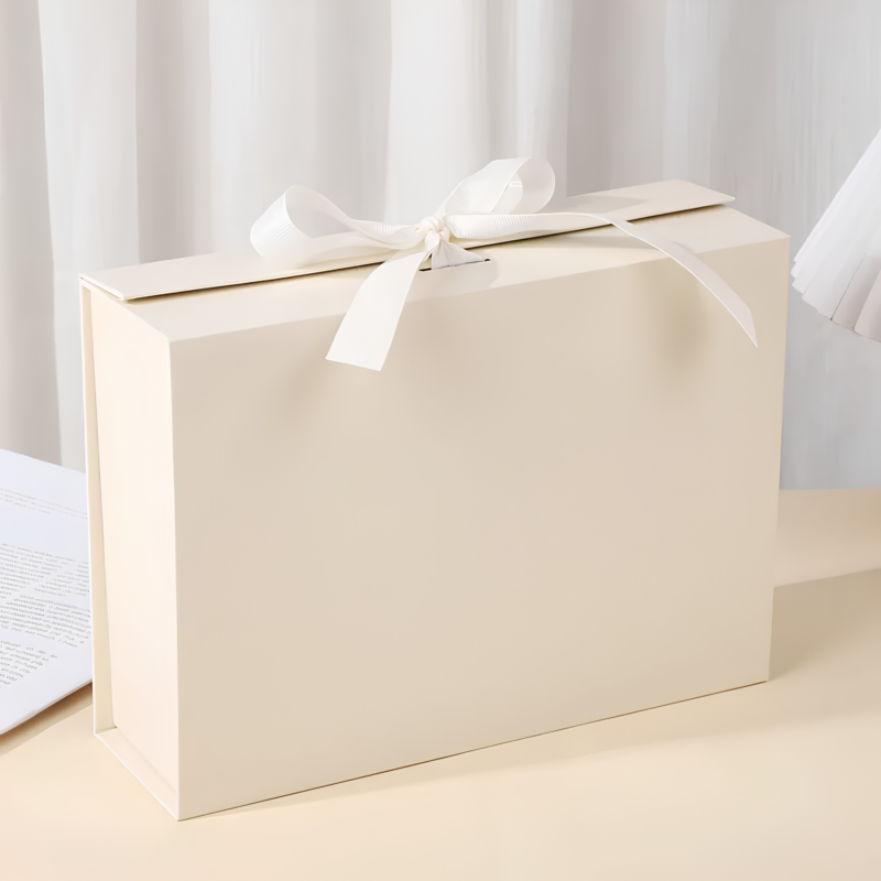 Open beige foldable gift box with magnetic closure and matching ribbon.