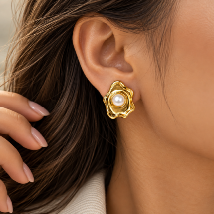 Pair of gold-coloured earrings with smooth white pearl-like centres and sculpted wavy frames on a white background.