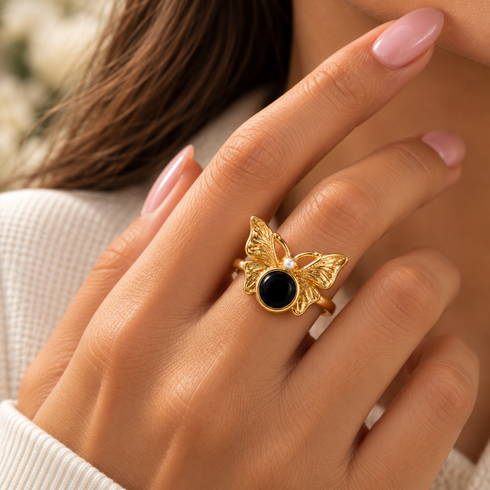 Noir Butterfly Ring Gold-coloured butterfly ring with detailed wings, a round black centre and small white accent on a white background.